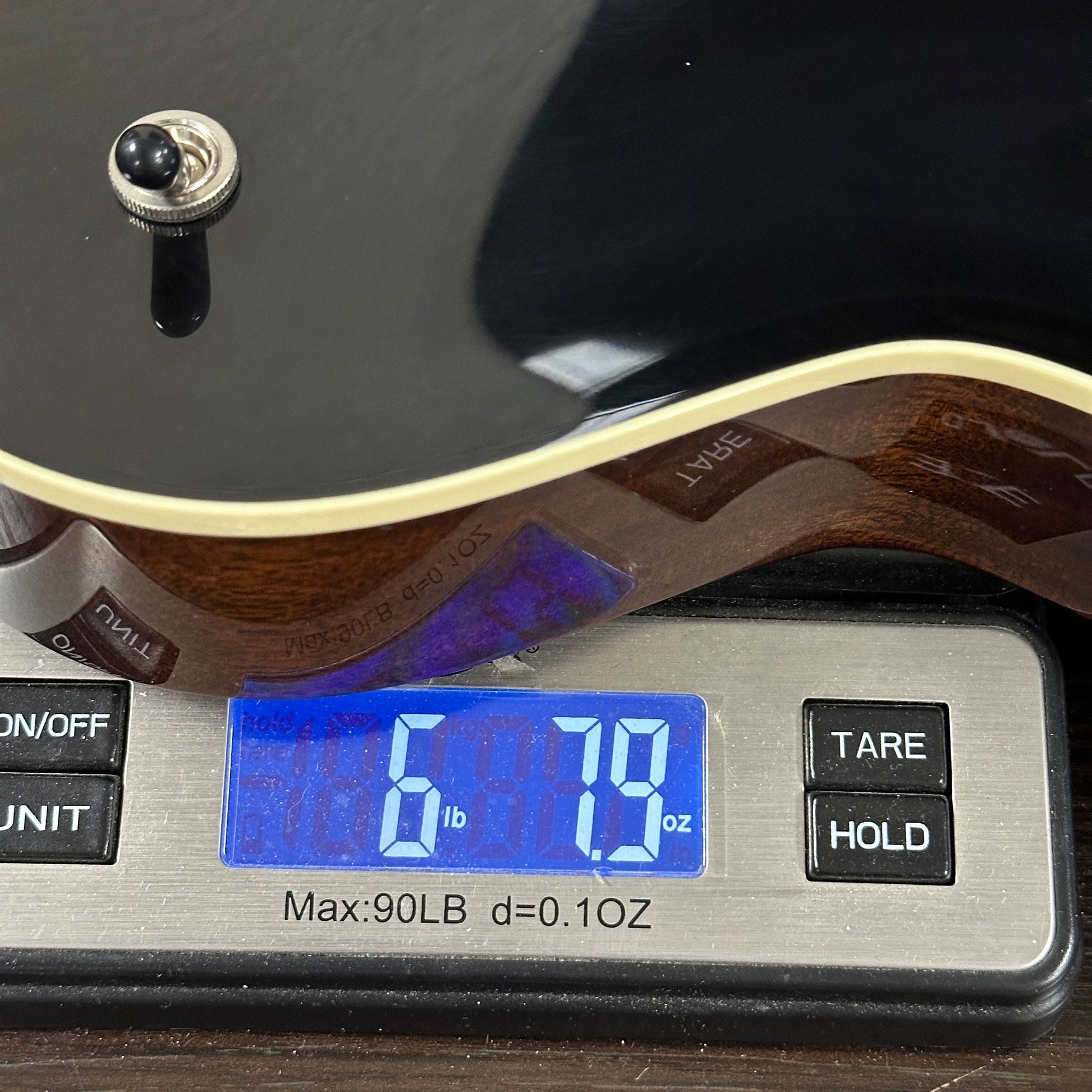 Collings 470-JL Antiqued Black on scale displaying weight.