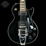 Black electric guitar with 'Tone Shop' logo in the corner