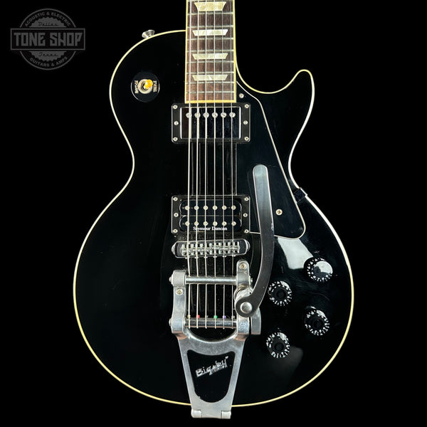 Black electric guitar with 'Tone Shop' logo in the corner