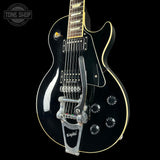 Black electric guitar with visible brand logo on a black background