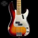 A classic four-string bass guitar with a sunburst finish, featuring a dark red outer edge, a bright orange center, and a white pickguard. The neck is made of light-colored wood with black frets and inlays.