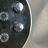 Close-up of a metallic control panel with four circular dials on a gray background