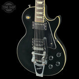 Black electric guitar with 'Tone Shop' logo in the corner