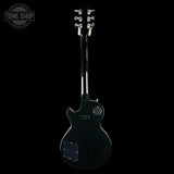 Black electric guitar on a white background with 'Tone Shop' logo.