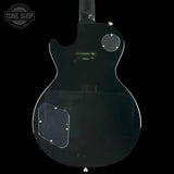 Back view of a black electric guitar with 'Tone Shop' logo.