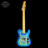 A Fender Telecaster electric guitar with a vibrant blue body featuring a colorful floral pattern, a natural maple neck, and a black headstock, shown against a solid black background.
