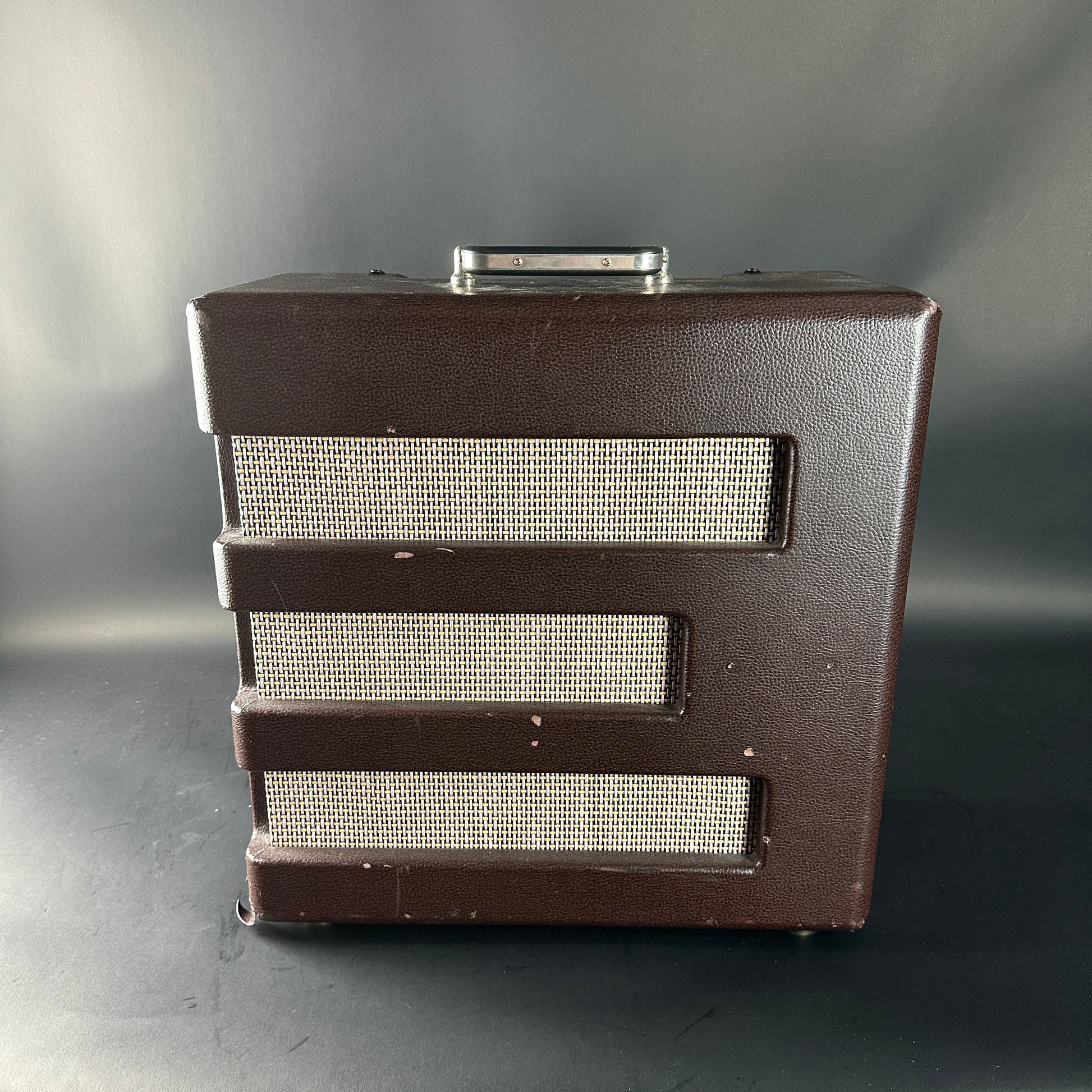 Brown speaker cabinet with metallic grill on a gray background
