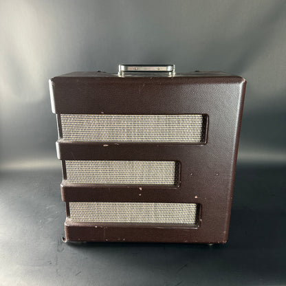 Brown speaker cabinet with metallic grill on a gray background