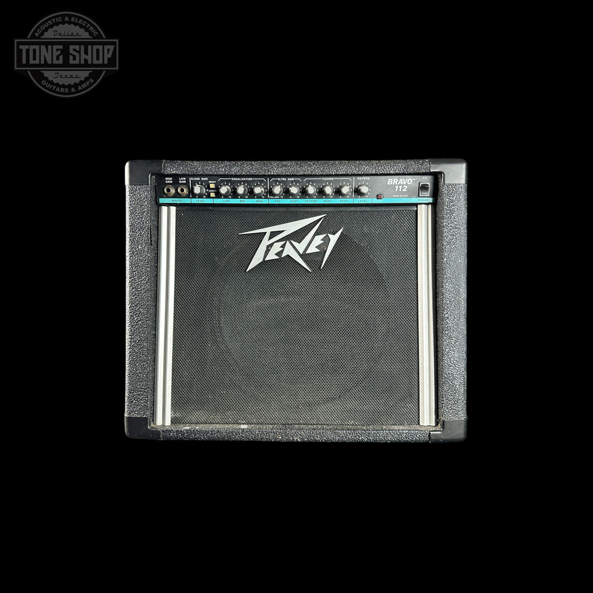 A Peavey 112 guitar amplifier cabinet shown from the front against a solid black background. The cabinet features a textured gray front, a black speaker grille with the white Peavey logo, and a control panel with knobs at the top.