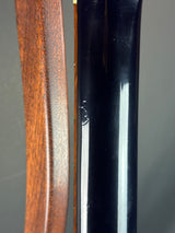 Close-up of a black and wooden object with a metallic strip on a gray background