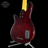 Glossy red electric guitar on a stand with 'Tone Shop' logo in the corner.