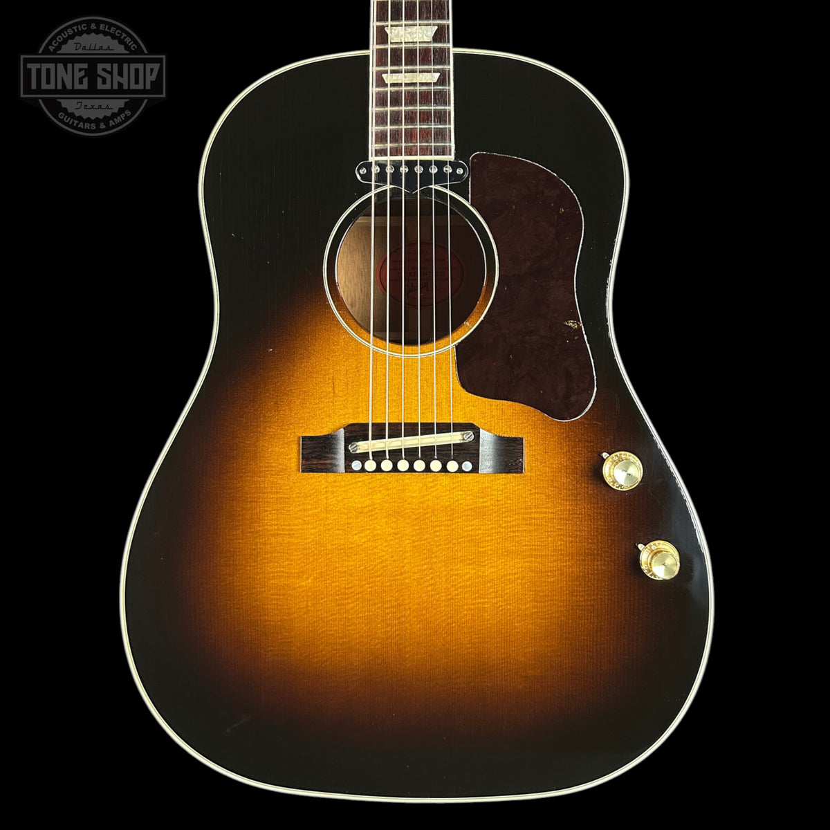Acoustic guitar with a sunburst finish on a black background, featuring the Tone Shop logo.