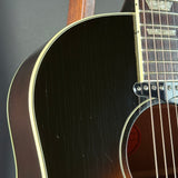Close-up of an acoustic guitar's soundhole and neck on a dark background