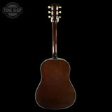 Back view of a brown acoustic guitar on a black background with 'Tone Shop' logo.