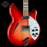 A red and orange sunburst electric guitar with a white pickguard, shown against a black background. A Tone Shop watermark is visible in the top-left corner.