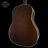 Back view of a brown acoustic guitar on a black background with 'Tone Shop' logo.