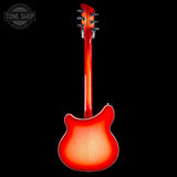 A red electric guitar shown from the back, featuring a glossy sunburst finish that transitions from bright red to amber, set against a solid black background with a Tone Shop watermark in the top left corner.