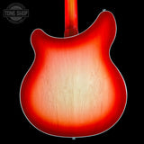 Close-up of the back of an electric guitar body with a red sunburst finish and visible wood grain, shown against a black background with a Tone Shop watermark in the upper left.