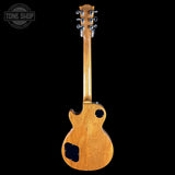 Back view of a wooden electric guitar on a black background with 'Tone Shop' logo.