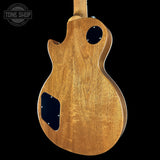 Back view of a wooden electric guitar with 'Tone Shop' logo in the corner.
