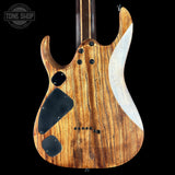 Wooden electric guitar with a black pickguard on a black background, featuring the Tone Shop logo.