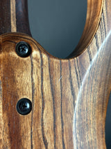 Close-up of a wooden object with two screws, possibly a gun stock or similar item.