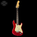 Red electric guitar with a white pickguard on a black background, featuring the Tone Shop logo.