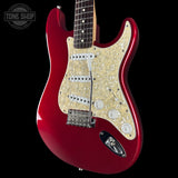 Red electric guitar with a visible brand logo on a black background