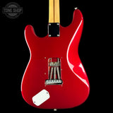 Red electric guitar with a black background, featuring the Tone Shop logo.