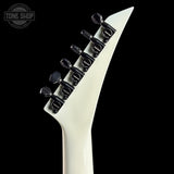 Close-up of a white electric guitar neck with black tuning pegs on a black background, featuring 'Tone Shop' logo.