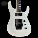 White electric guitar with a black pickguard on a black background