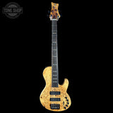 Electric bass guitar with a worn, gold finish on a black background, featuring the Tone Shop logo.
