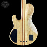Wooden electric guitar body with visible grain on a black background, featuring 'Tone Shop' logo.