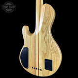 Wooden electric guitar body with 'Tone Shop' logo in the corner
