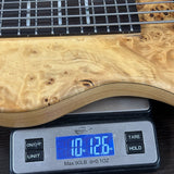 Wooden guitar on a digital scale displaying weight