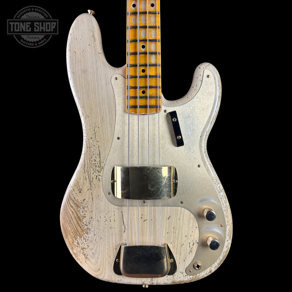 A custom Fender-style electric bass guitar with a heavily distressed white pickguard and body, a natural maple neck, and black hardware, shown against a solid black background with a Tone Shop watermark in the top left.