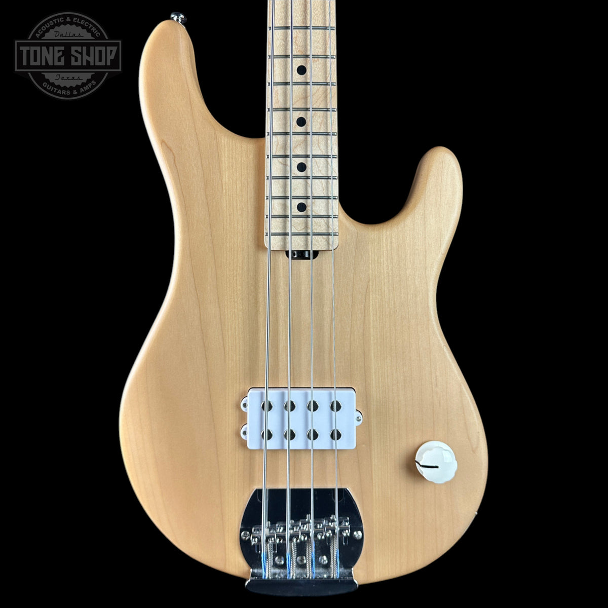Electric bass guitar with a natural wood finish on a black background, featuring the Tone Shop logo.