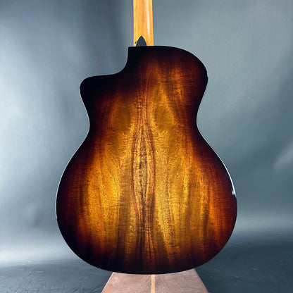 Back view of a brown acoustic guitar on a gray background