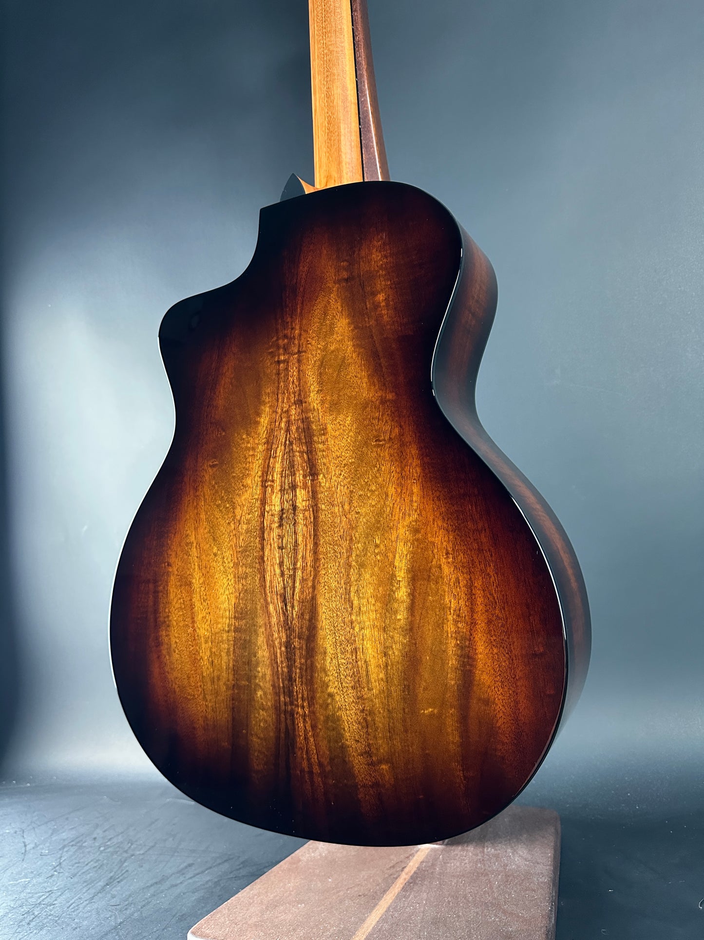 Close-up of a wooden acoustic guitar on a dark background