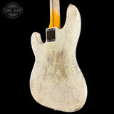 The back of a Fender Stratocaster electric guitar with a heavily distressed, worn-off white finish, showing the natural wood grain underneath. The neck has a yellow-orange fade, and a black Fender logo plate is visible.
