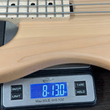 Wooden bass guitar on a digital scale displaying weight