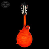 A mandolin shown from the back, featuring a vibrant orange-red flamed maple wood finish and a black headstock with silver tuning pegs, set against a solid black background with a Tone Shop watermark in the top left corner.
