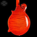 Close-up of the back of an electric mandolin with a vibrant orange-red flamed maple finish, set against a solid black background. A Tone Shop watermark is visible in the top-left corner.