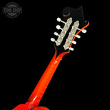 Close-up of the headstock and neck of a six-string electric guitar with a glossy orange-red finish and silver tuning machines, shown against a black background with a Tone Shop watermark in the top left.