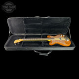 Electric bass guitar in a black case with 'Tone Shop' logo.