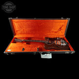 Electric guitar in an open case with 'Tone Shop' branding.
