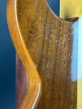 Close-up of a wooden gun stock with visible grain and texture.