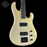 White electric bass guitar on a black background with 'Tone Shop' logo.