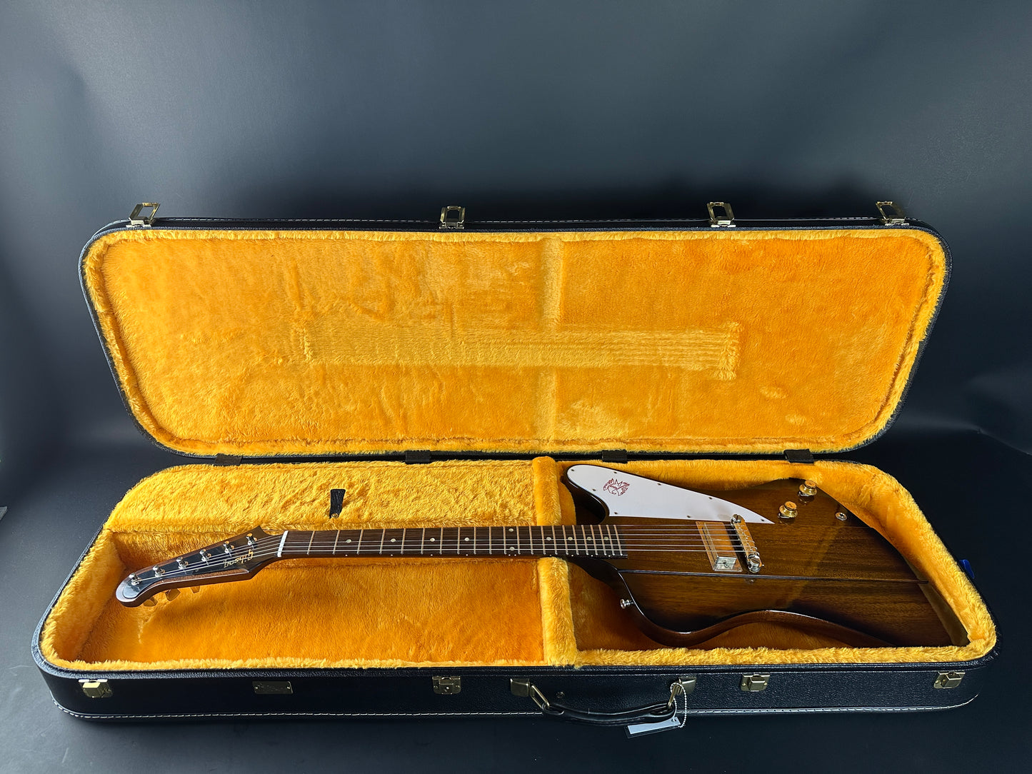 Guitar in an open case on a dark background