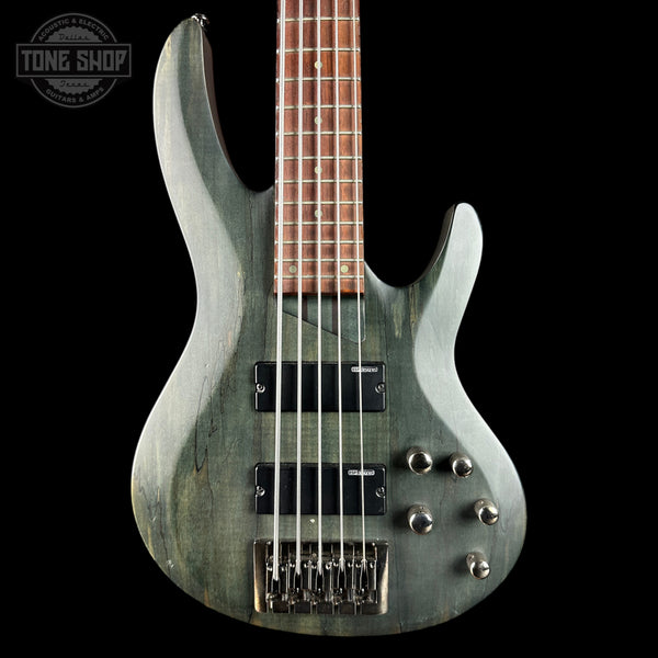 Electric bass guitar with a metallic finish on a black background, featuring the Tone Shop logo.